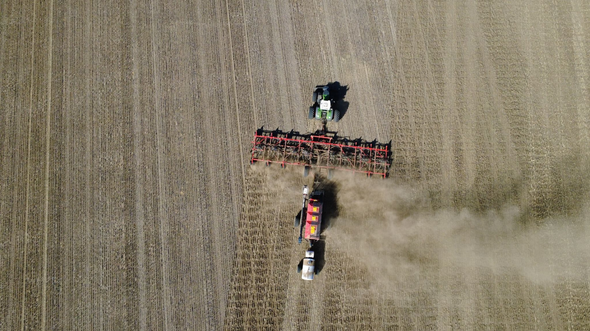 Overhead view of a tractor and air seeder sowing into stubble